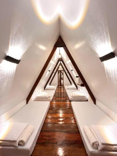 a room with a row of beds in a attic at Dahun Villas Siargao in General Luna