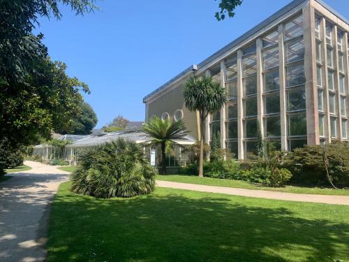 a large building with palm trees in front of it at La Passerelle in Cherbourg en Cotentin