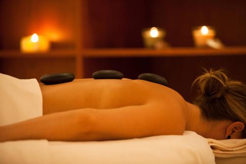 a nude woman laying on a bed with massage balls on her back at Praia D'El Rey Marriott Golf & Beach Resort in Casal da Lagoa Seca