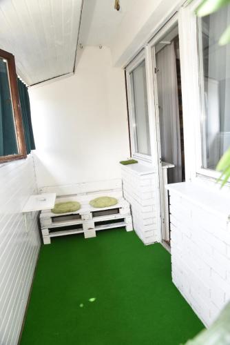 a room with a green floor and two windows at Apartman K2 in Valjevo