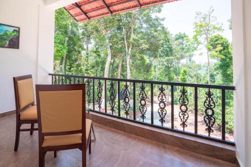 a room with a balcony with a view of trees at Navut Homestay - Serenity Among Coffee Plantations in Virajpet