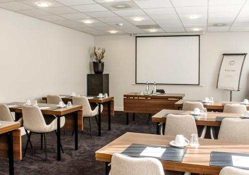 a classroom with tables and chairs and a whiteboard at Amrâth Grand Hotel Frans Hals in Haarlem