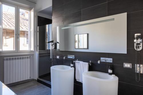 a bathroom with two white sinks and a window at Now Apartments, ApartHotel in the heart of Rome in Rome