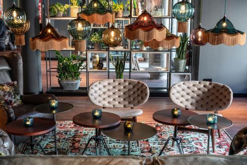 a room with two chairs and tables and lamps at Motel One Berlin Mitte in Berlin