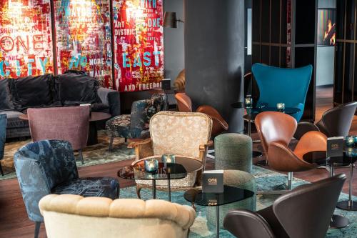 a living room with chairs and tables and a couch at Motel One Berlin Mitte in Berlin