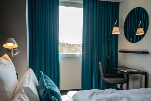 a bedroom with a bed and a desk and a window at Motel One Berlin Mitte in Berlin