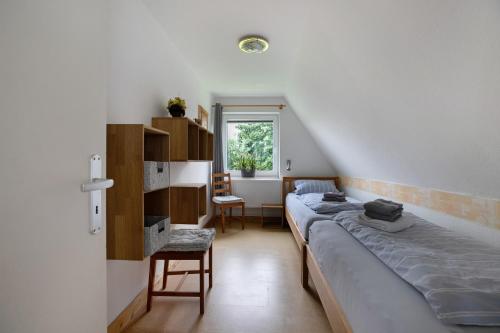 a bedroom with a bed and a desk and a window at Hus an Diek in Hillgroven