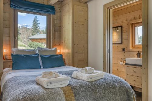 a bedroom with a bed with towels on it at Chalet Monte Bianco I Luxe I Bain nordique I Sauna in Combloux