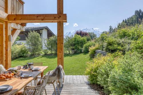 a dog standing on a patio with a table at Chalet Monte Bianco I Luxe I Bain nordique I Sauna in Combloux