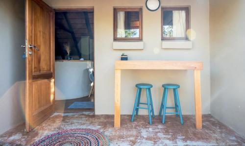 a kitchen with a wooden table and two stools at Hoedspruit Unit 37 in Hoedspruit