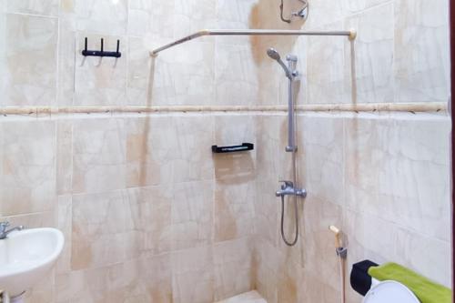 a bathroom with a shower and a sink at RedDoorz Syariah at Chilla Guest House Padang in Padang