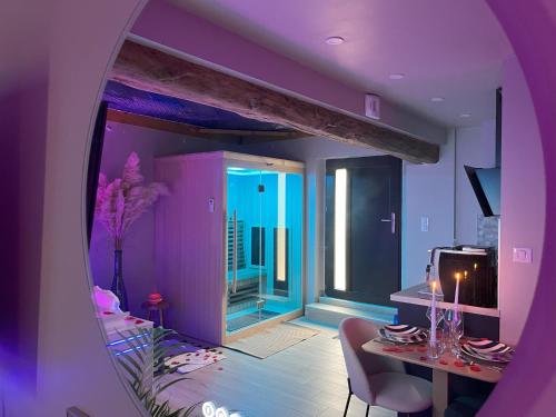 a purple room with a dining table and a window at L'Écrin d'Azurite in Saint-Clair-sur-les-Monts