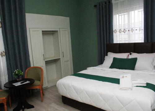 a bedroom with a bed and a table and a chair at Ramat Luxury Hotel in Mangpontin