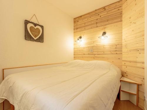 - une chambre avec un lit et une photo de cœur sur le mur dans l'établissement Appartement cosy 4 pers, balcon Mont Blanc, à 100m des pistes - FR-1-353-108, à La Plagne Tarentaise