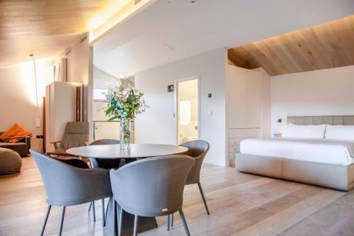 a dining room with a table and chairs and a bed at MYR Plaza Mercado & Spa in Valencia