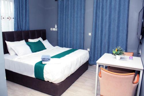 a bedroom with a large bed with blue curtains at Ramat Luxury Hotel in Mangpontin