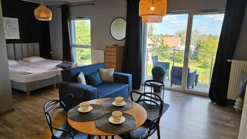 salon z dwoma stołami i kanapą w obiekcie Apartament Buk w mieście Buk