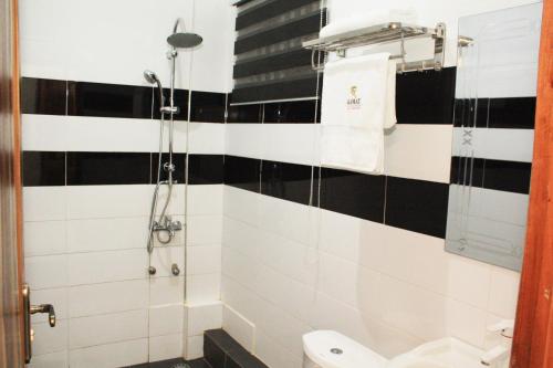 a bathroom with a black and white tiled wall at Ramat Luxury Hotel in Mangpontin