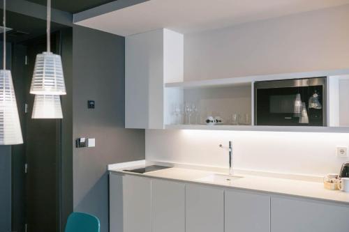 a kitchen with white cabinets and a sink at MYR Plaza Mercado & Spa in Valencia