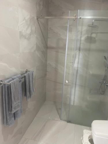 a shower with a glass door in a bathroom at Homestay Ocean Real in Phan Thiet
