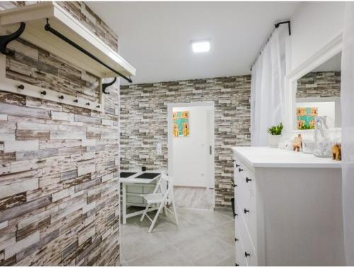 a bathroom with a brick wall and a sink at Malasits 2 private room with shared bathroom in Győr