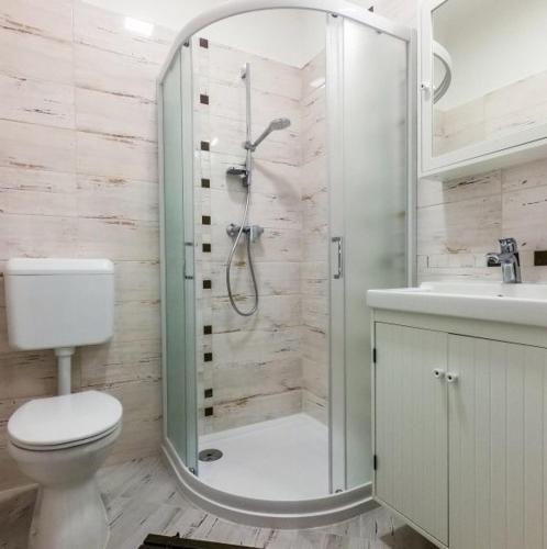 a bathroom with a shower and a toilet and a sink at Malasits 2 private room with shared bathroom in Győr