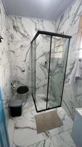 a marble bathroom with a shower and a toilet at Casa Jabuticabeira in Ouro Preto