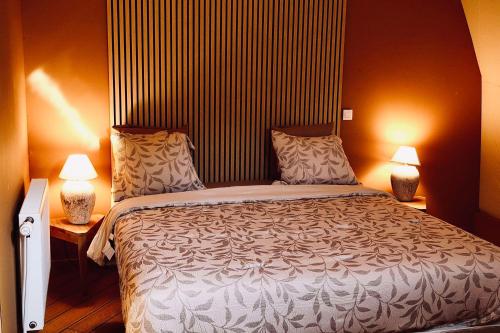 a bedroom with a large bed and two lamps at Le Hameau Arribas in Condé-Sainte-Libiaire