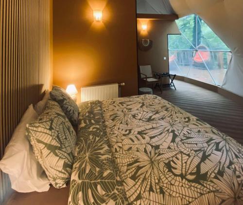 a bedroom with a bed with a comforter and pillows at Le Hameau Arribas in Condé-Sainte-Libiaire