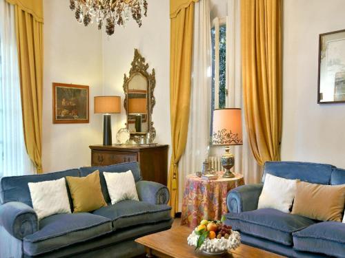 a living room with two blue couches and a mirror at Spacious Mansion, Casciana in Lari