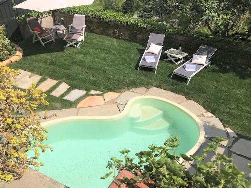 a small swimming pool with two chairs and a table at Spacious Mansion, Casciana in Lari
