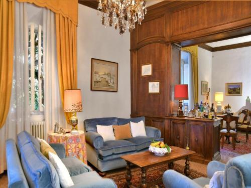 a living room with blue furniture and a chandelier at Spacious Mansion, Casciana in Lari