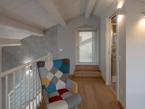 a living room with a chair and a staircase at Apartment in Montelupone near Porto Recanati in Montelupone