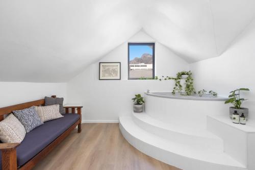 Habitación blanca con sofá y lavamanos en Uptown Retreat by Host Agents, en Ciudad del Cabo