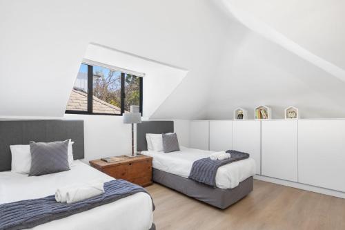 Un dormitorio con dos camas y una ventana. en Uptown Retreat by Host Agents, en Ciudad del Cabo