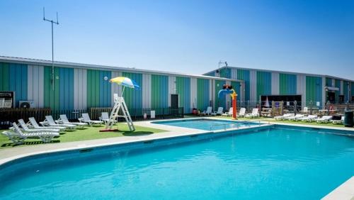 ein Hotel mit einem Pool mit Stühlen und einem Sonnenschirm in der Unterkunft 361 seawick in Saint Osyth