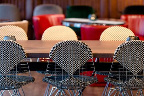a group of chairs sitting around a wooden table at Motel One Frankfurt-Eastside in Frankfurt/Main