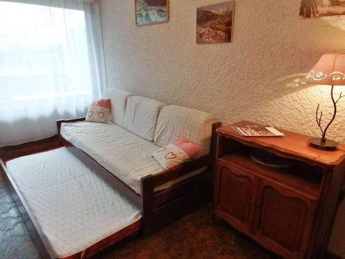 - un petit lit dans une chambre avec une table dans l'établissement Studio en Rez-de-Jardin pour 4 avec Parking Couvert, à 500m de la Télécabine - Le Grand-Bornand - FR-1-241-80, au Grand-Bornand