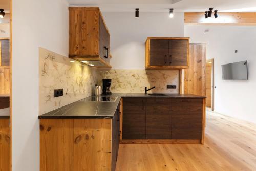 a kitchen with wooden cabinets and a counter top at Apartments Schlernheim in Fie allo Sciliar