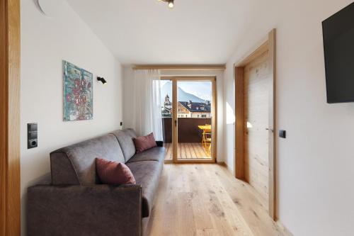 a living room with a couch and a sliding glass door at Apartments Schlernheim in Fie allo Sciliar