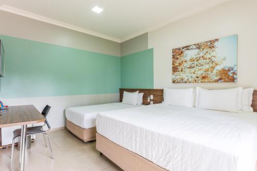 two beds in a room with a table and a desk at Ucayali Hotel in Sinop