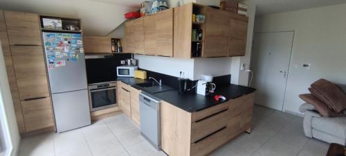 une cuisine avec des armoires en bois et un réfrigérateur blanc dans l'établissement Au cœur du vignoble, à Kaysersberg