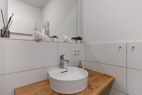 Un baño blanco con lavabo y espejo. en Km Style Apartment Nr 2, en Freiburg im Breisgau