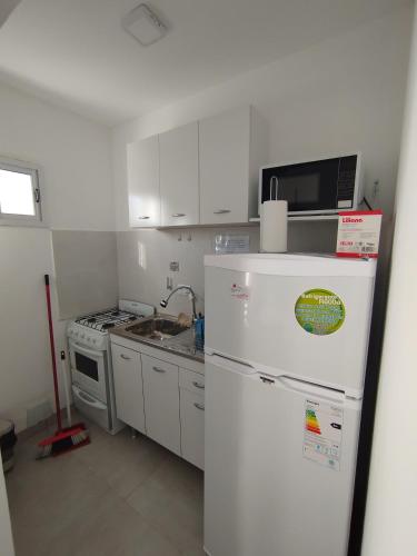 a kitchen with a white refrigerator and a sink at Camino 124 NQN in Neuquén