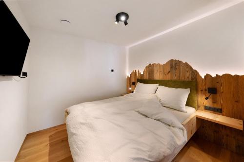 a bedroom with a large bed with a wooden headboard at Apartments Schlernheim in Fie allo Sciliar
