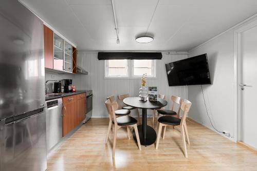 a kitchen with a table and chairs and a television at Enter Amalie Apartment Hotel in Tromsø