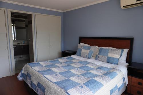 a blue bedroom with a bed with a blue and white blanket at Pontoni Providencia in Santiago
