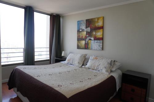 a bedroom with a bed with two pillows on it at Pontoni Providencia in Santiago