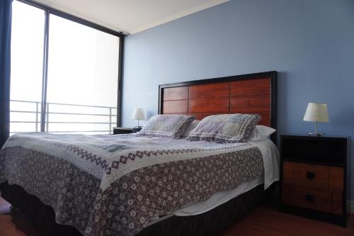 a bedroom with a large bed and large windows at Pontoni Providencia in Santiago