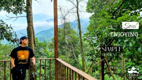 a man standing on a bridge in the forest at Xieng Retreat in Hanoi